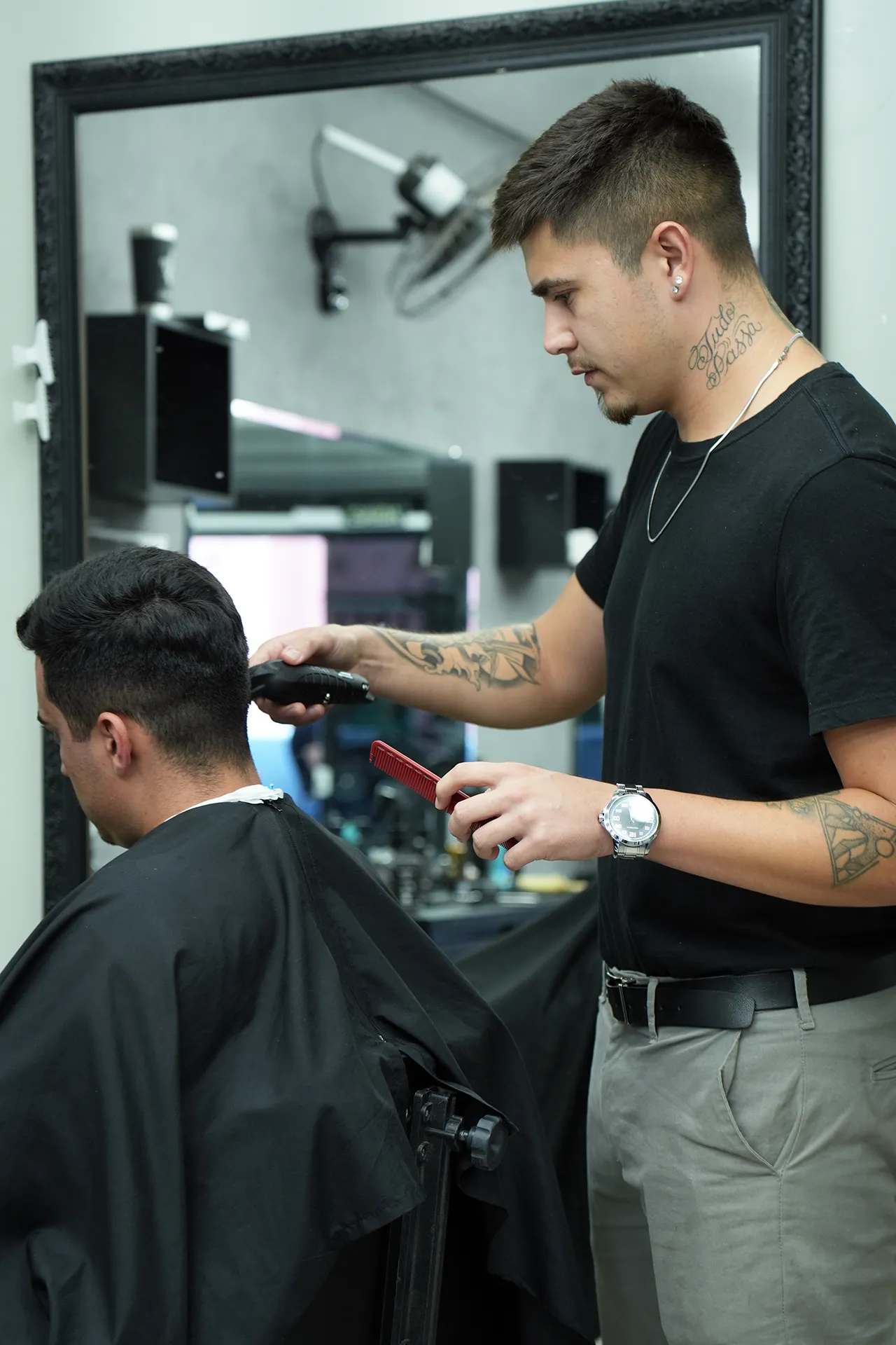 Barbeiro da Barbearia XV realizando um corte